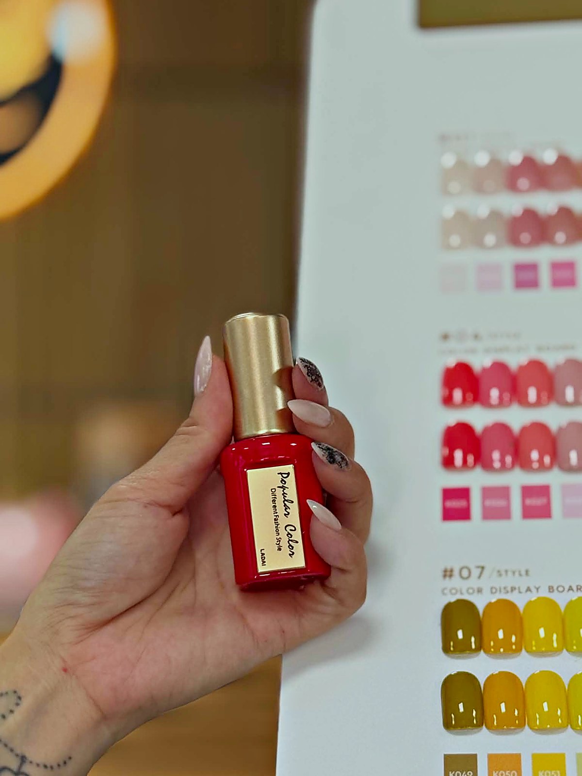 Nagellackflasche vor der Farbkarte zur Farbberatung bei Elly Nails Frankfurt Ostend
