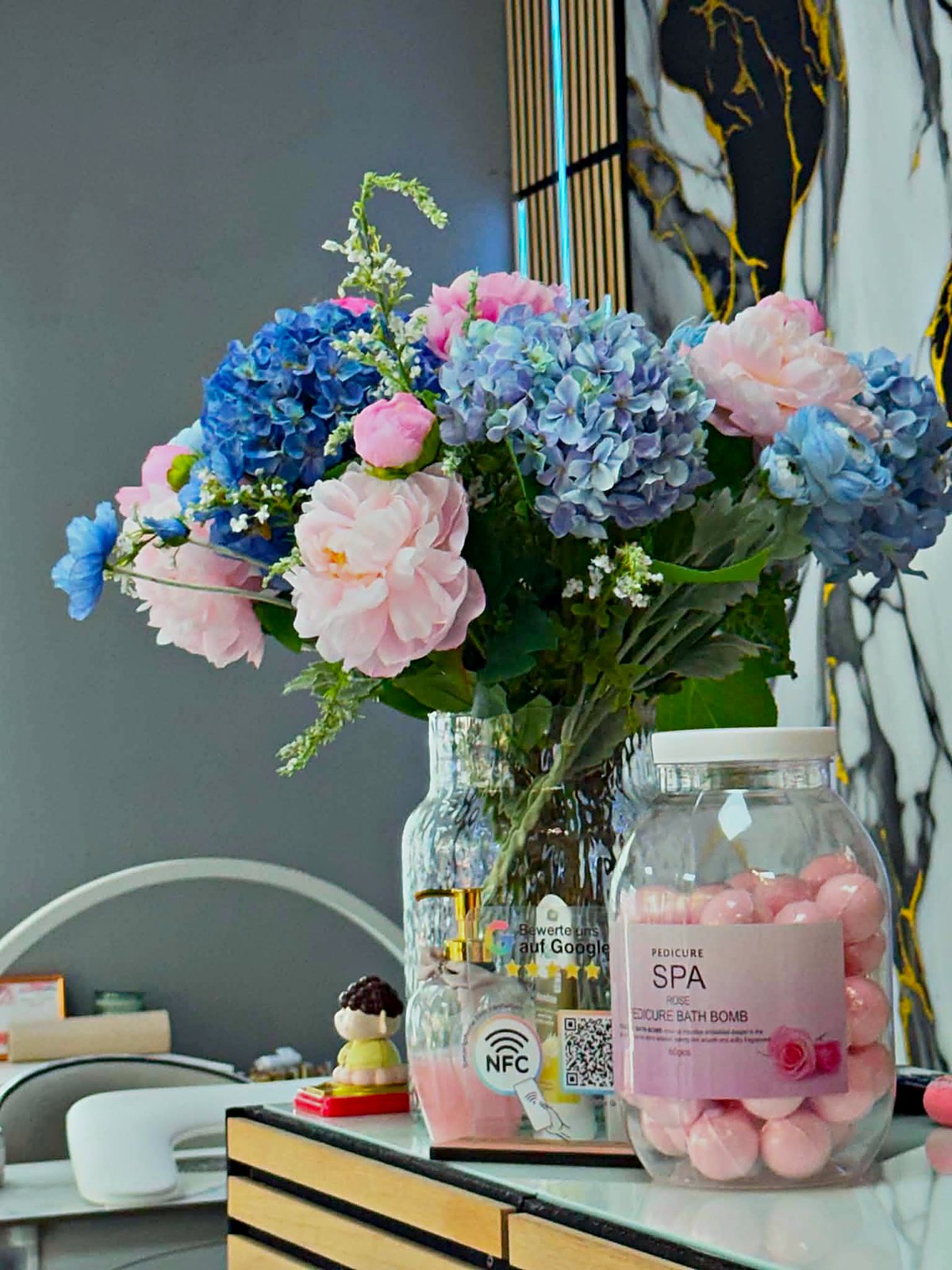 Pflegeprodukte und frische Blumen auf dem Tresen im Elly Nails Studio Frankfurt Ostend